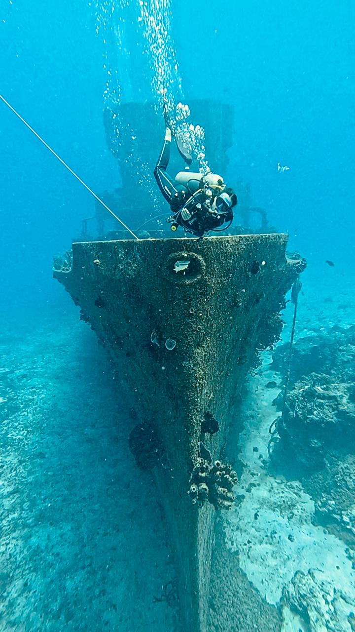 Diver over wreck bow in Cozumel